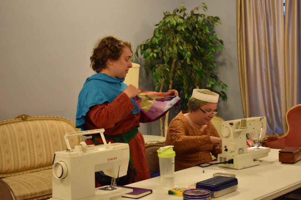 Eva and Sancha work on garb repair for Lilies.